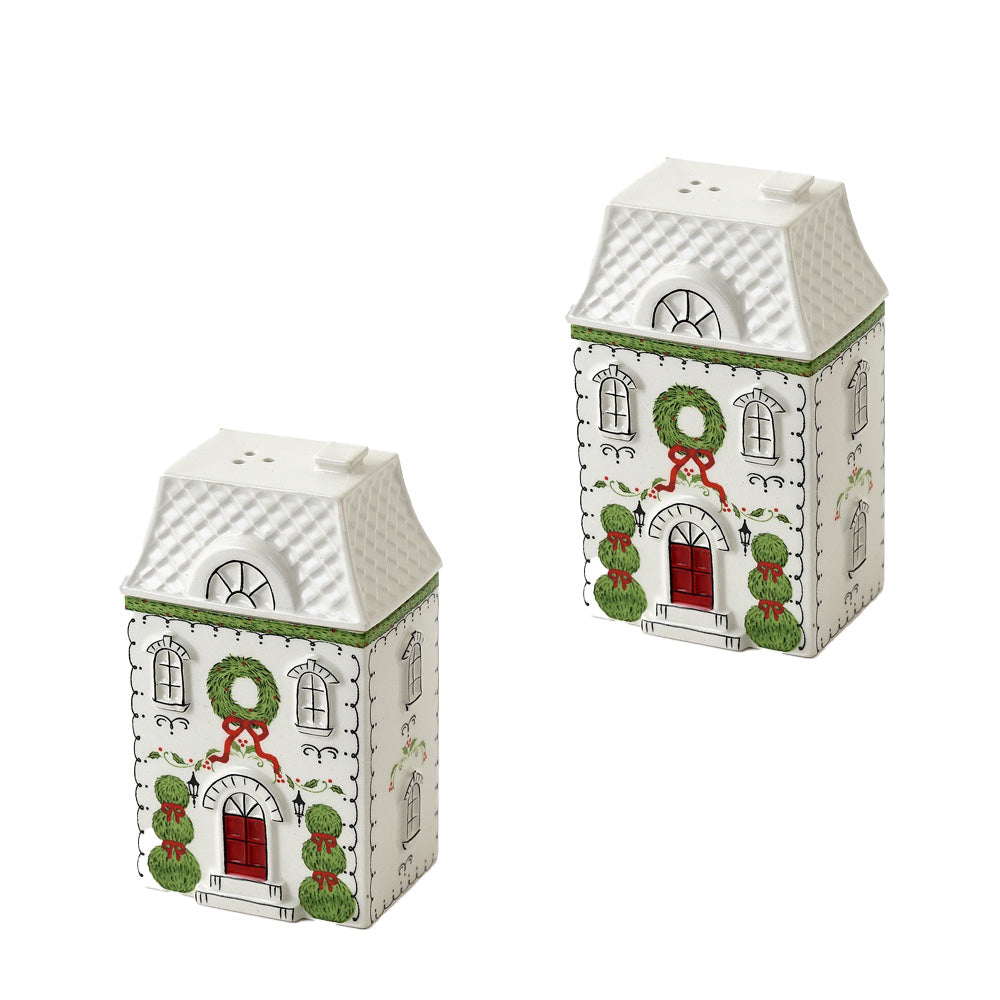 Two white Christmas house-shaped salt and pepper shakers with green wreaths, red doors, and green topiary trees.
