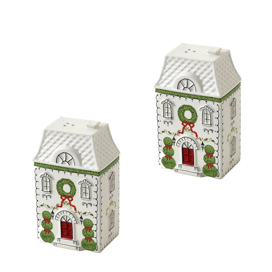 Two white Christmas house-shaped salt and pepper shakers with green wreaths, red doors, and green topiary trees.