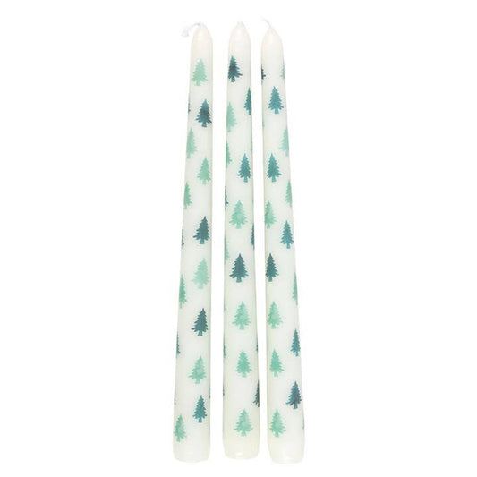 Three white candles with green tree patterns on a white background