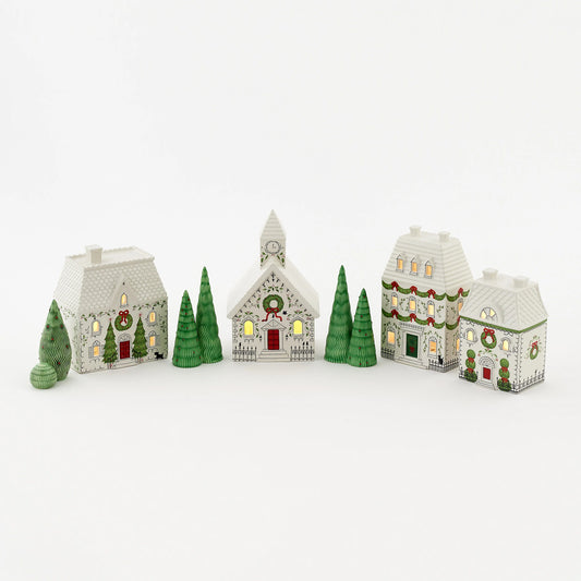 A set of small decorative Christmas village houses and trees in white, green, and red.