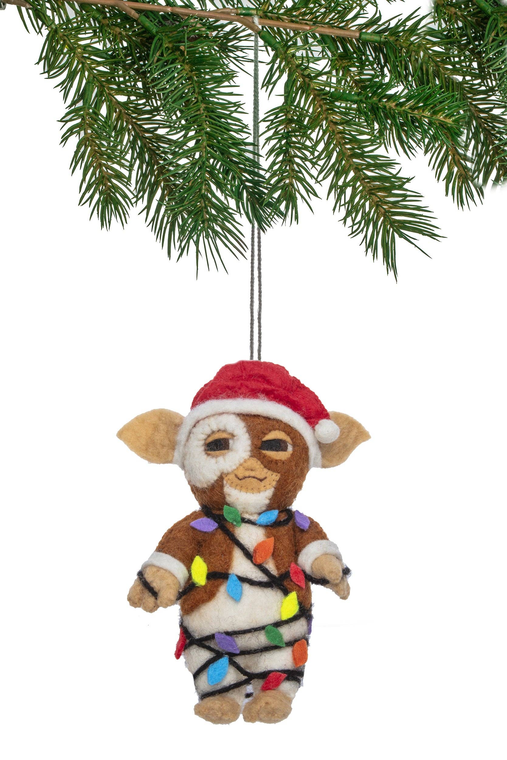 A felt Christmas ornament made to resemble Gizmo. Wearing a red Santa hat and wrapped in multicolored holiday lights