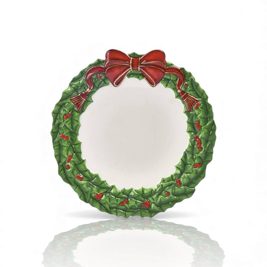 Decorative Christmas wreath plate set with a red bow.
