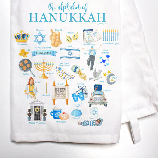Towel with illustrations and text related to Hanukkah on a white background
