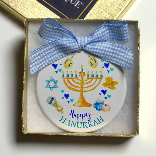 Porcelain ornament  with Hanukkah design and a blue bow that comes in a gold gift box  