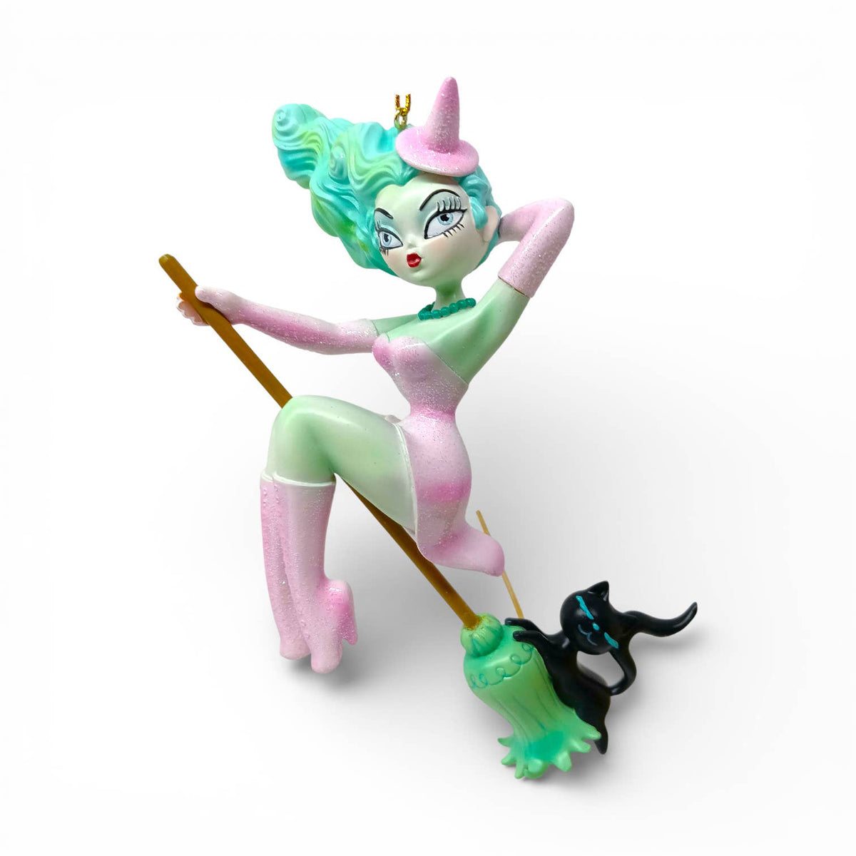 Loretta is a colorful figurine of a character with teal hair and pink outfit holding a broom with a black cat 