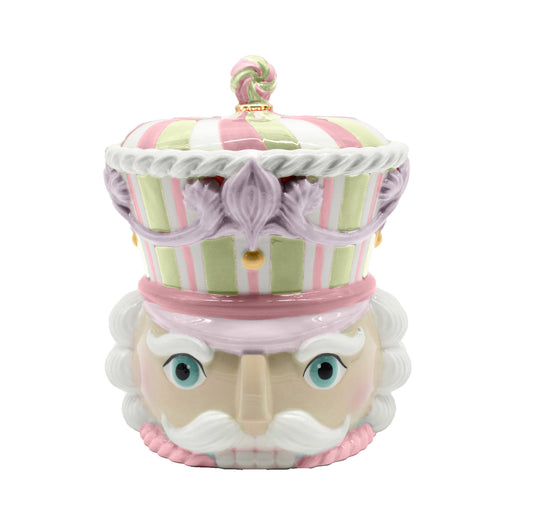 Decorative cookie jar made to resemble the head of a nutcracker in colors of pink and mint green. 