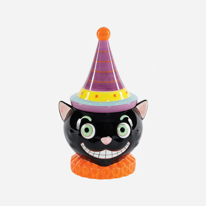 A ceramic black cat figurine cookie jar wearing a purple party hat with orange stripes, a yellow band, and a light blue brim, standing on an orange ruffled base  
