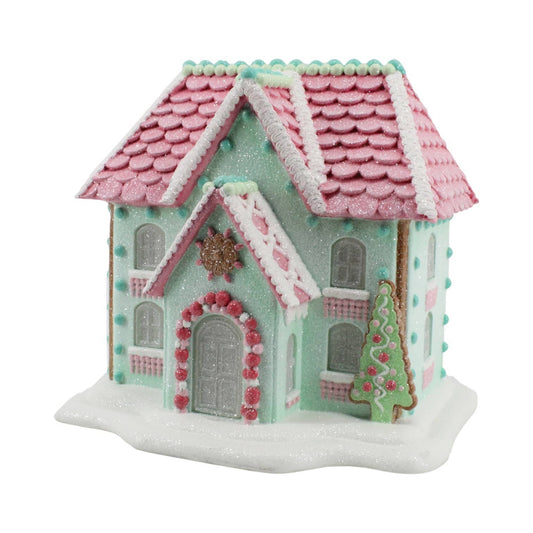 Pastel color LED lighted gingerbread house with pink roof and green body.