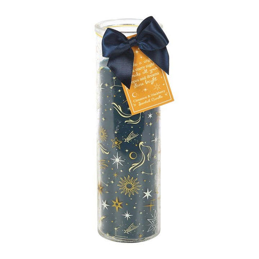 Decorative candle in glass tube with star patterns, navy bow, and orange hang tag 