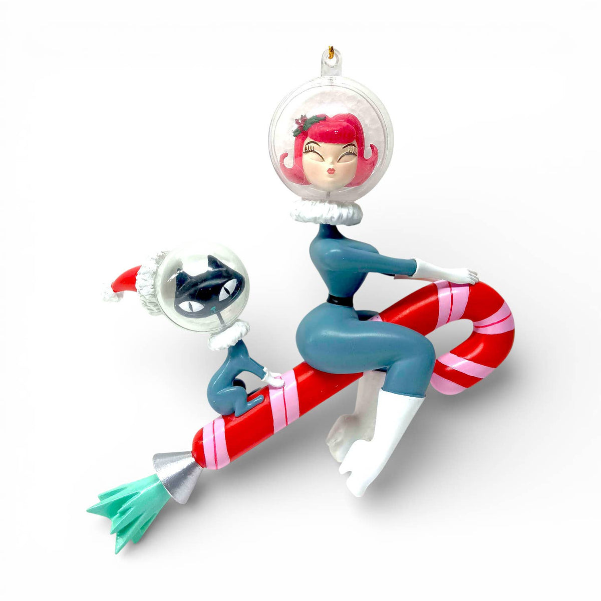 Hanging ornament featuring a female astronaut and cat riding on a candy cane rocket.