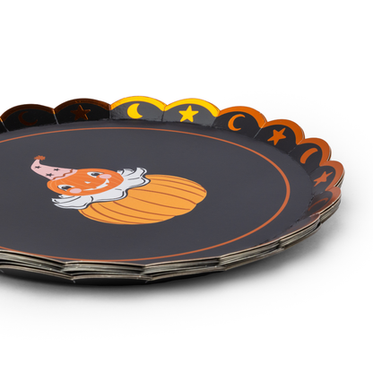 A stack of round Halloween party paper plates with scalloped edges,