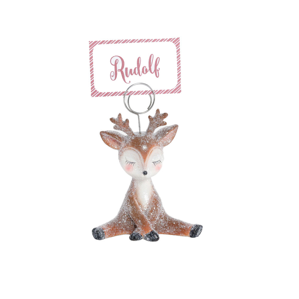 A small reindeer placecard holder with glittery finish, a white face and chest, brown body, and black nose and hooves. 
