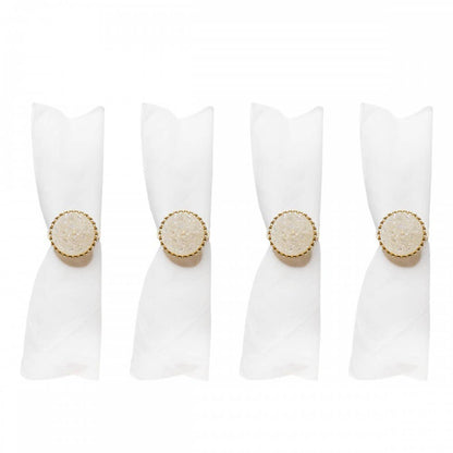 Four white napkin rings with gold circular designs 