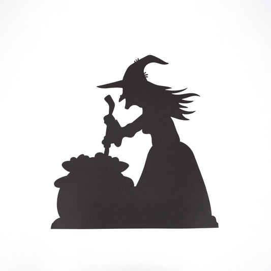 Die-Cut paper placemats of a black silhouette of a witch casting a spell over a cauldron 
